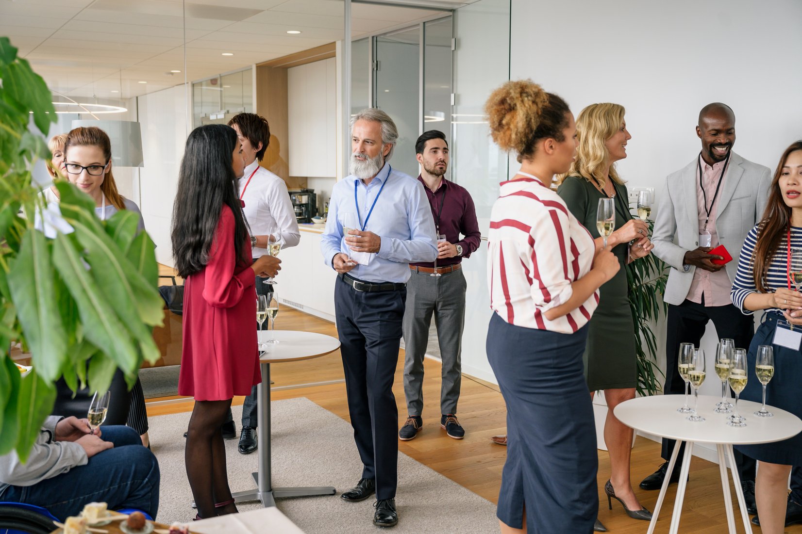 Business people socializing with champagne at office event