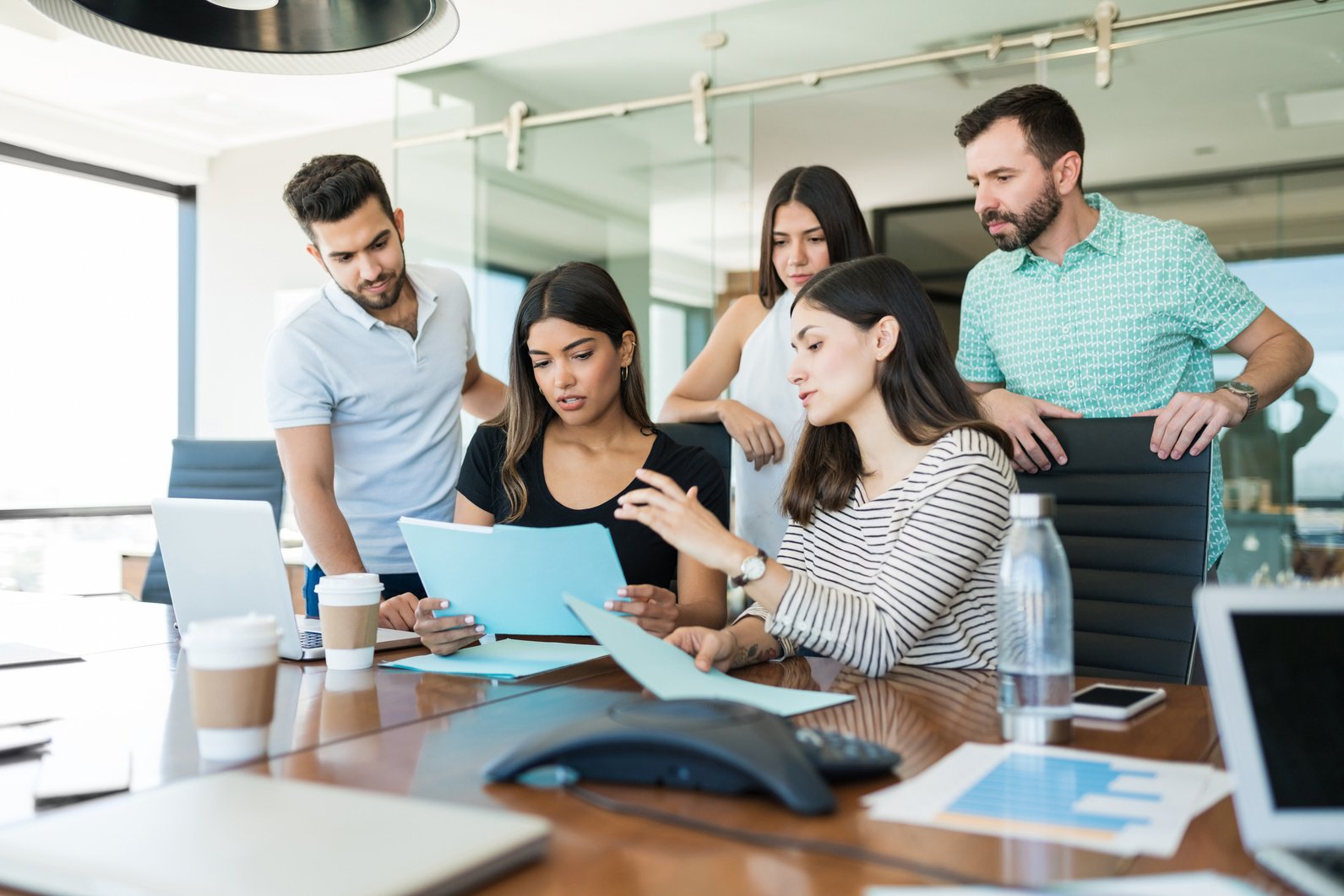 Hispanic Colleagues Coworking In Meeting Room